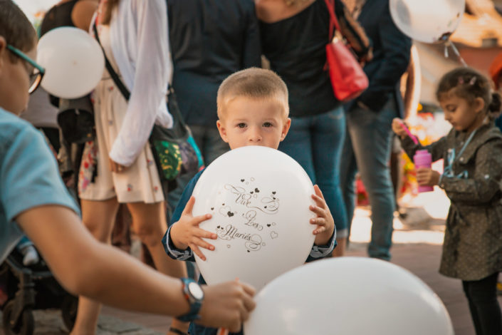Un enfant attend les mariés avec un ballon