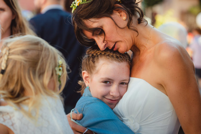 La mariée embrasse une invitée à la sortie de la cérémonie civile